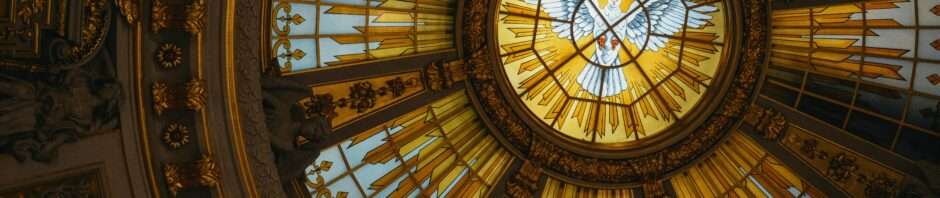 Beautiful stained glass dome depicting a dove in a golden, ornate setting.